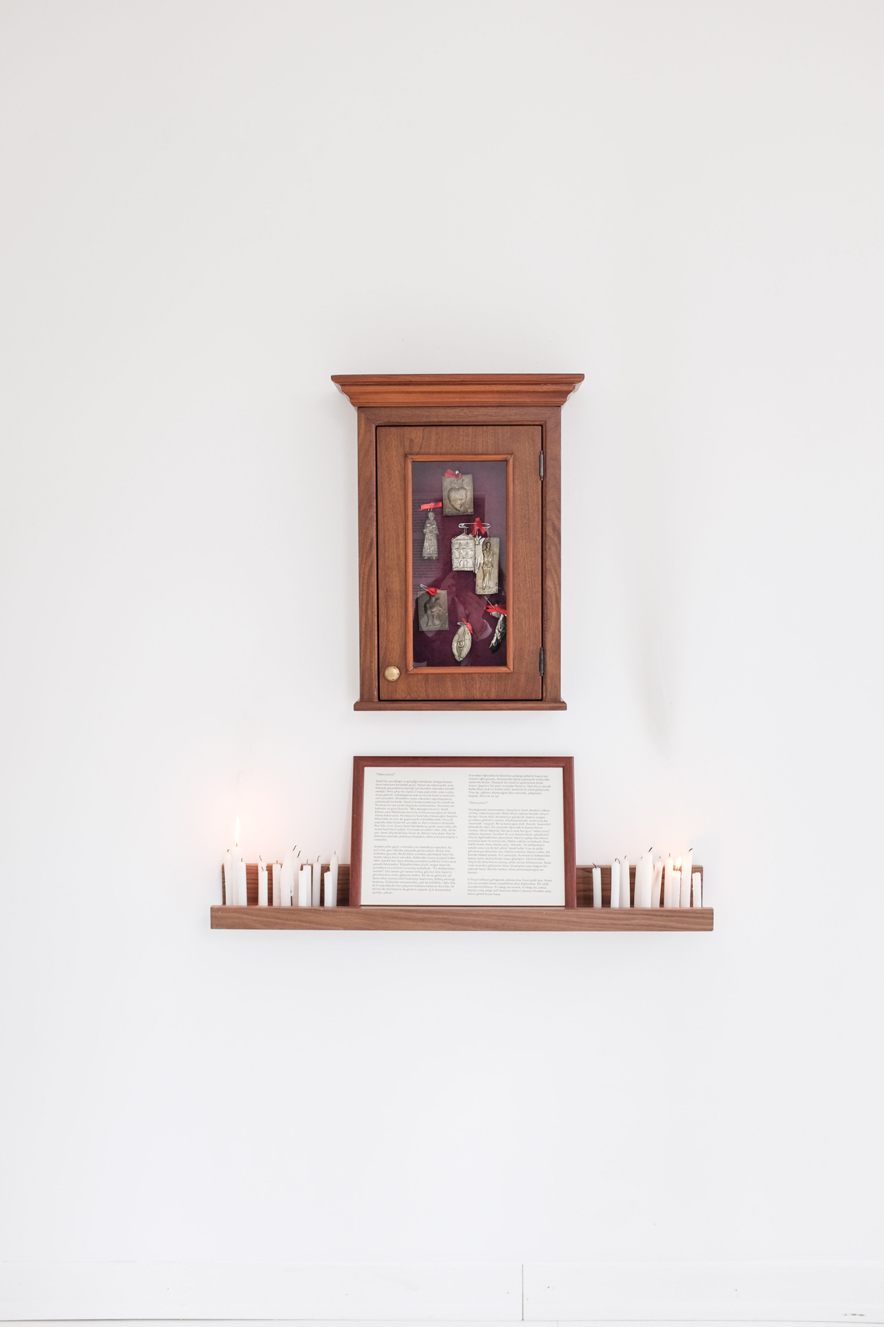 A Chance For A Miracle, 2018 , Installation view, ex votives,cabinet 50x40, candles, framed text, Dimensions variable.